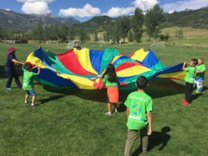 Summer Advantage students outside playing with a parachute